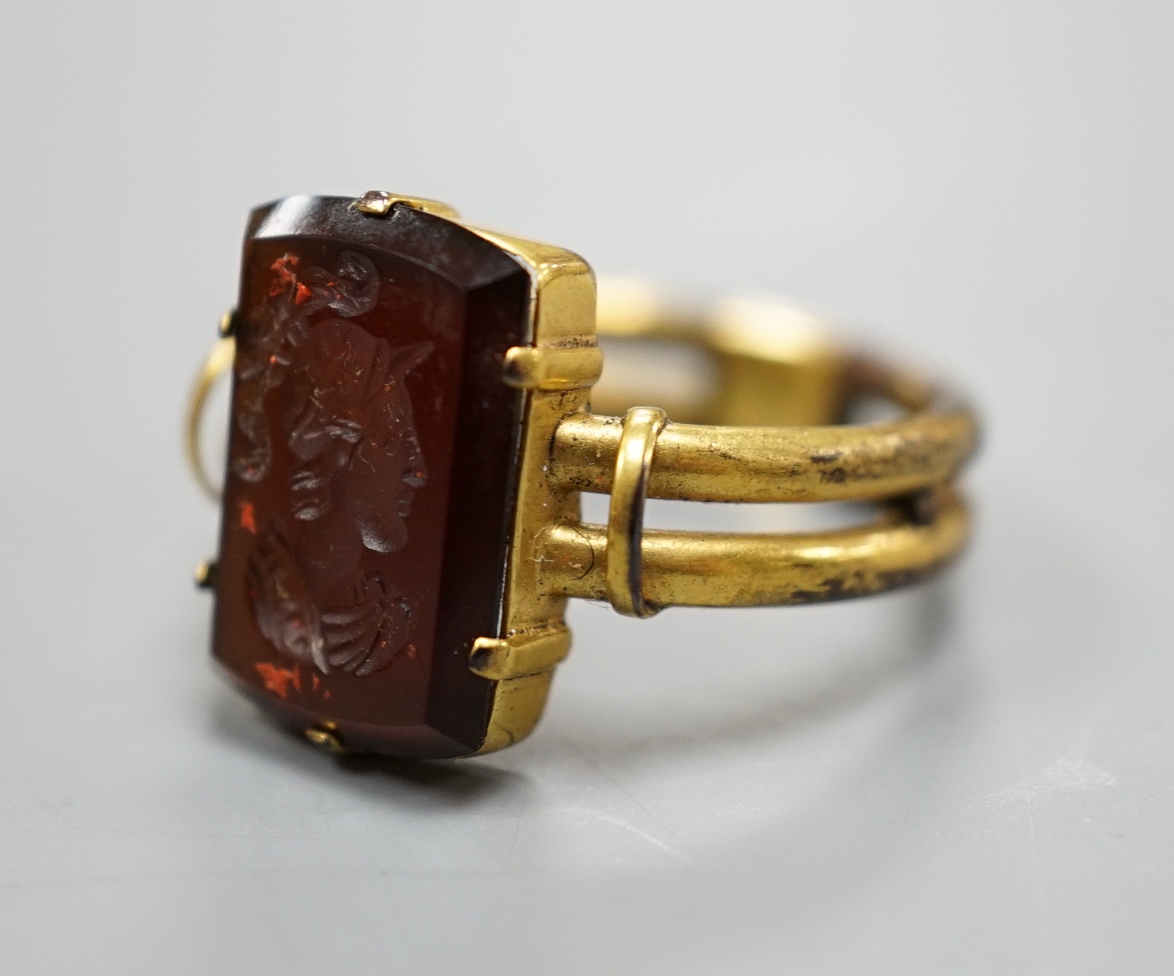 A 19th century yellow metal overlaid and rectangular intaglio chalcedony set ring, the matrix carved with the bust of a Roman soldier to sinister, size O, gross weight 2.7 grams.